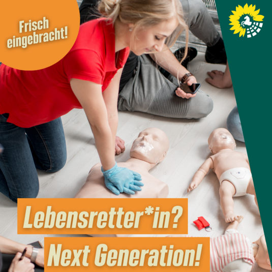 Auf dem Bild sind mehrere Menschen zu sehen, die an Puppen die Herz-Lungen-Wiederbelebung üben. Die Überschrift in beige lautet "Lebensretter*in? Next Generation!" auf orangenem Hintergrund. Oben links in der Ecke ist ein orangener Kreis mit der Schrift "Frisch eingebracht!". Oben rechts in der Ecke ist ein dunkelgrünes Dreieck und das Logo der Grünen Landtagsfraktion. 